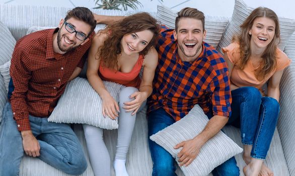 cheerful group of friends laugh ,sitting on the couch.