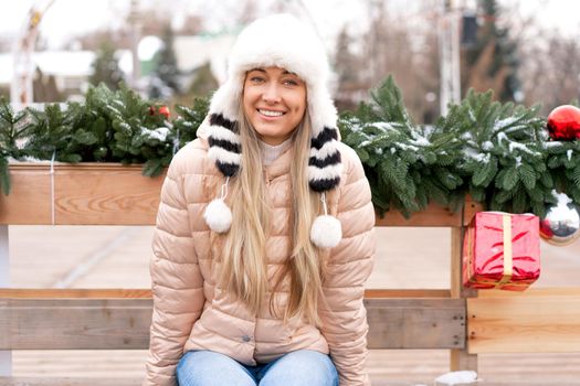 Winter portrait young adult beautiful blonde woman wearing funny fluffy hat. Christmas mood. Snowing winter beauty fashion concept