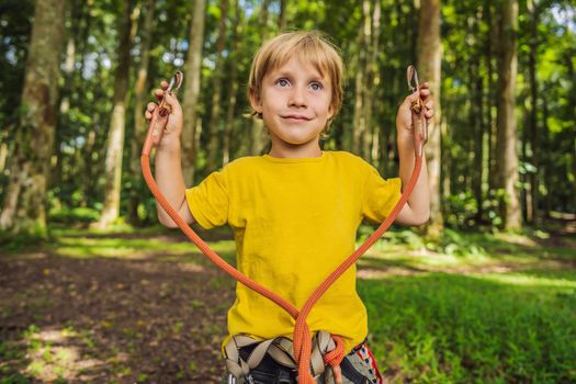 Little boy in a rope park. Active physical recreation of the child in the fresh air in the park. Training for children