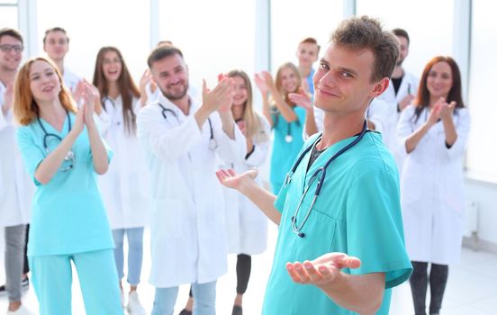 large team of doctors applauds the young professional
