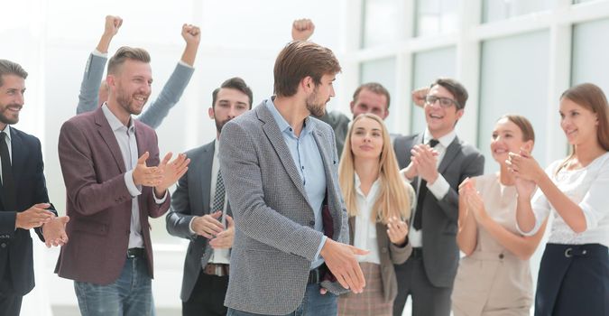 cheerful employees congratulating a colleague on the promotion