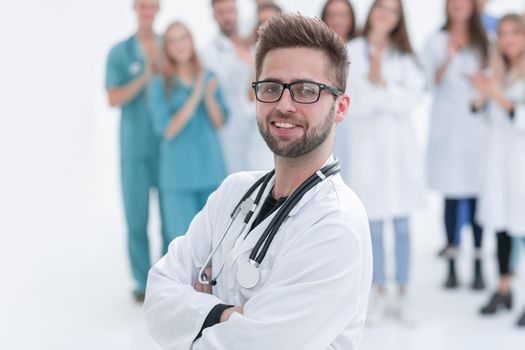 smiling chief doctor standing in front of his colleagues
