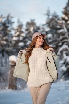 A model girl walking through a snow-covered forest, a demonstration of clothes.