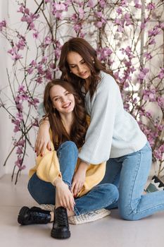 Two girls, models, have fun and smile in a photo studio. Expression of emotions