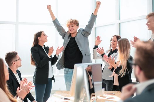 boss and happy employees applaud standing in the office