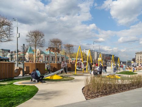 MOSCOW, RUSSIA - May 01, 2022. Local people and tourists have a rest on playground of square near Paveletsky railway. Modern urban architecture.