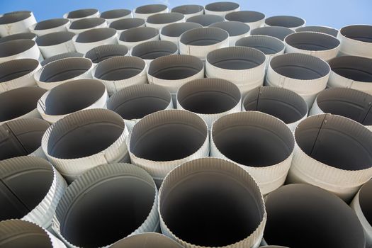 Downpipe warehouse. Steel pipes, parts for the construction of a roof drainage system in a warehouse. Stack of stainless steel pipes.