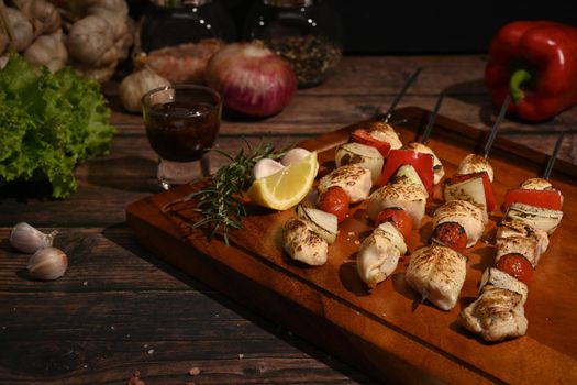 Tasty grilled chicken skewers with barbecue sauce and ingredients on wooden background
