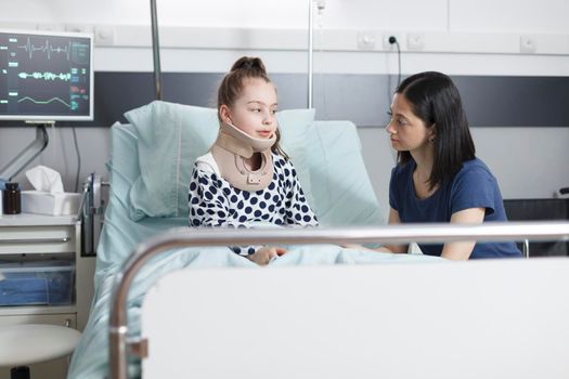 Neck injured little girl talking to worried anxious mother about accident
