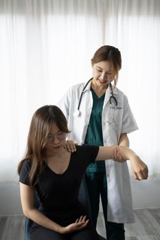 Caring female physiotherapist working with patient in clinic. Physiotherapist Insurance concept.