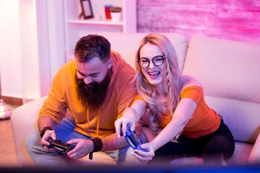 Beautiful young couple entertaining themselves playing online video games