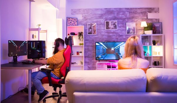 Couple playing different shooter games in their room