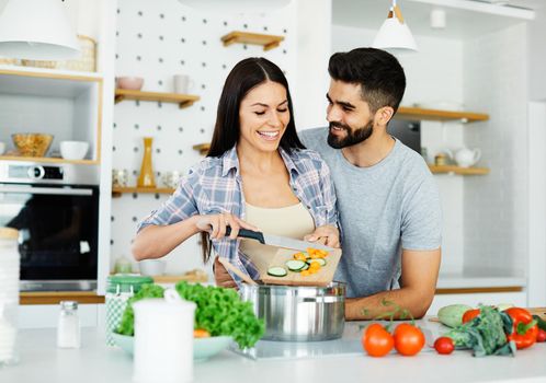 young couple kitchen home cooking love happy together preparation ingredient fun food