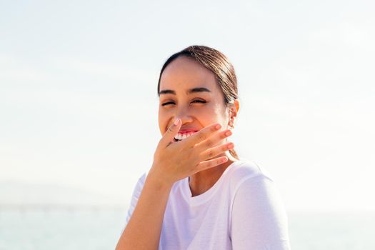 young woman laughing and covering her mouth