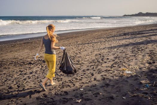 Young woman cleaning up the beach. Natural education of children