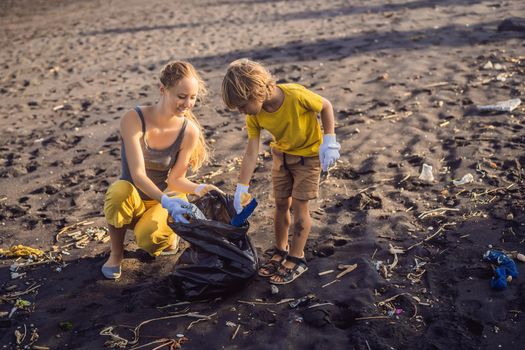 Mother and son are cleaning up the beach. Natural education of children