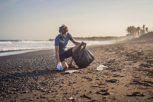 Young man cleaning up the beach. Natural education of children