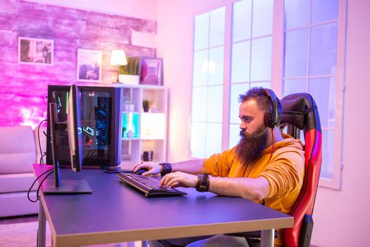 Professional gamer with long beard in front of powerful gaming rig