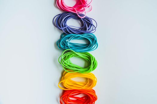 Top view of colorful rubber bands isolated on white. Rainbow elastic rubber bands on white