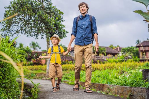 Father and son tourists in Bali walks along the narrow cozy streets of Ubud. Bali is a popular tourist destination. Travel to Bali concept. Traveling with children concept