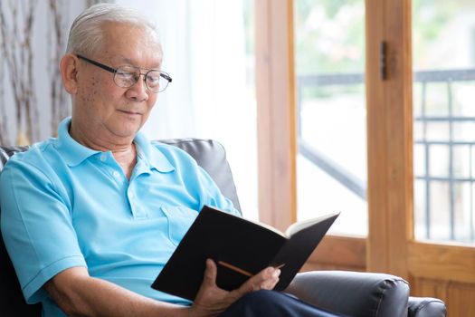Senior man reading book and stay alone at home.