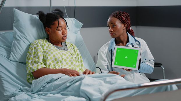 Physician holding digital tablet with horizontal green screen