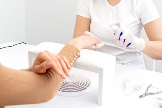 manicurist disinfects the client's fingers