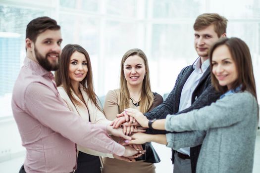 concept of teamwork:friendly business team standing in a circle, hands clasped together