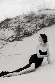 girl in a black long dress in a sandy desert