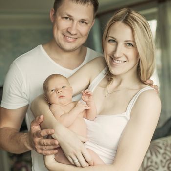 concept of family happiness - portrait of happy parents and newb