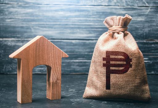 Wooden house and a philippine peso money bag. Mortgage loan. House project development. Rental business. Realtor services. Generating income from rent or sale. Home purchase, investment in real estate