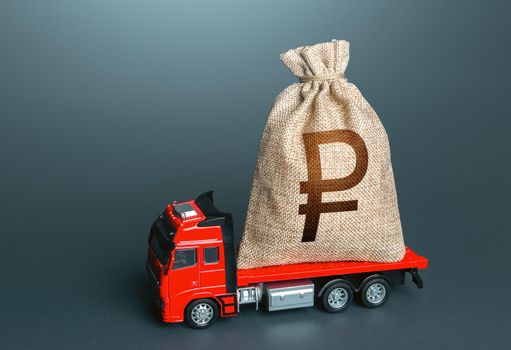 Truck with a russian ruble money bag. Financial aid, investments and subsidies. Compensation. High super income. Payment of taxes. Cash collection. Money transfers and transactions. Loan or deposit.