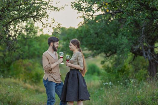 young couple drinking standing drinking wine from glasses