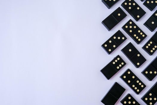 Black old, vintage dominoes on white background. The concept of the game dominoes. Selective focus. Copy space. Pastime