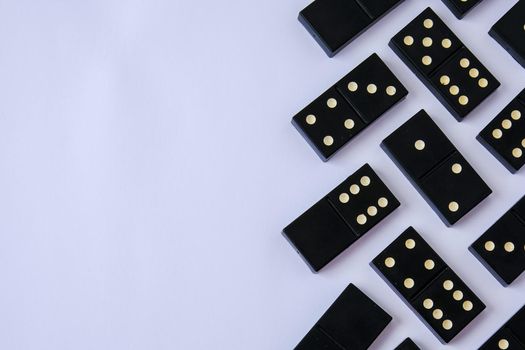 Black old, vintage dominoes on white background. The concept of the game dominoes. Selective focus. Copy space. Pastime
