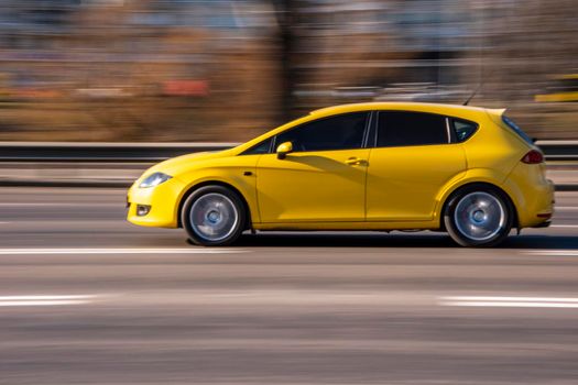 Ukraine, Kyiv - 11 March 2021: Yellow Seat Leon car moving on the street;