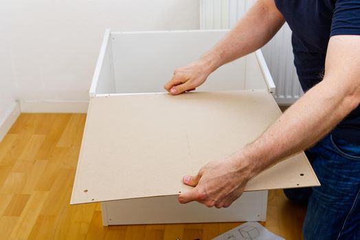 Professional Furniture Assembly Worker Assembles Shelf. Furniture assembly process. DIY Assembling