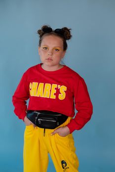 teenage girl in fashion stylish bright clothes. little lady in red and yellow on blue background. makeup and hairdo