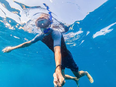 Man with mask snorkeling in clear water