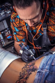 Tattoo artist makes cool tattoo in tattoo parlor