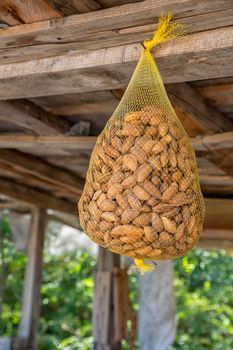 Hanging almond in nylon net bag at a market