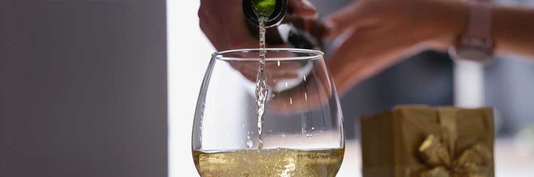 Woman pouring champagne into a glass, close-up