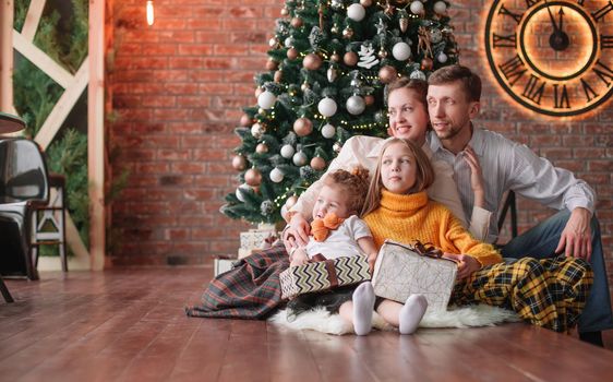 family with Christmas gifts in a cozy living room