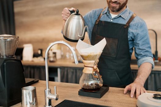 Close up of Barista pouring water on coffee ground with filter