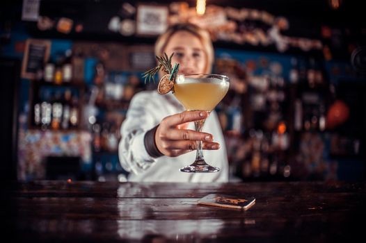 Portrait of woman mixologist formulates a cocktail at the bar counter