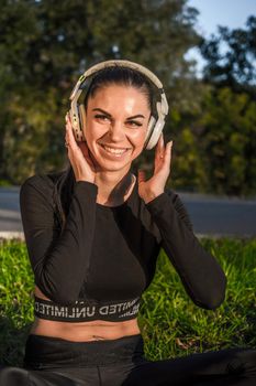 Sporty girl with headphones outdoors enjoying music