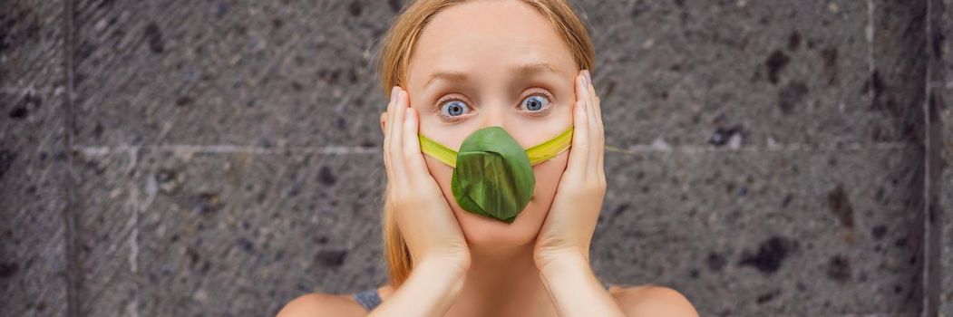 Woman made himself a face mask from the leaves to protect himself from air pollution. Air purification concept. Trees purify the air concept BANNER, LONG FORMAT