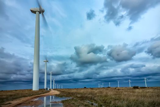 Wind turbine farm under the blue cloudy sky
