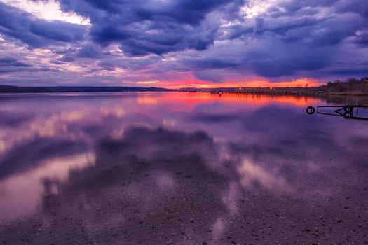 stunning dusk landscape at calm sea water with water reflection 