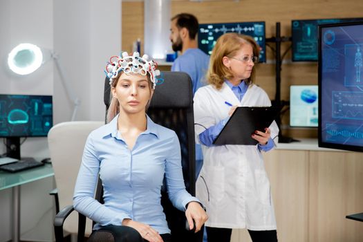 Doctor who monitors the patient's evolution during the neurology headset test and notes in the clipboard